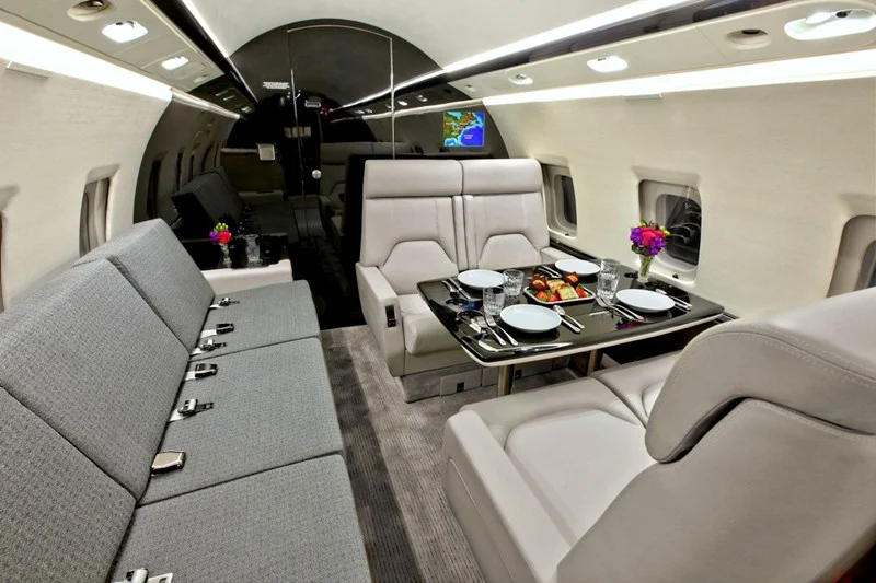 Challenger 604 cabin — the widest room in its class, table set for four