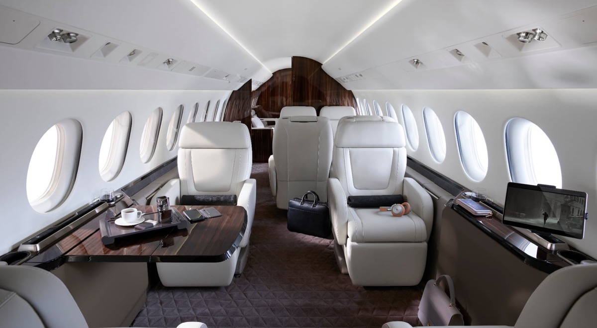 Falcon 8X cabin — the forward lounge in white leather and dark wood